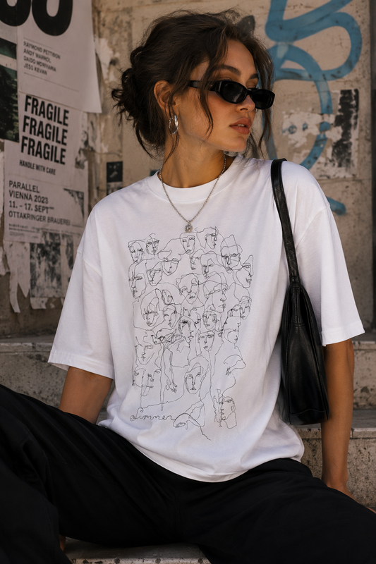 Woman wearing an oversized white T-shirt featuring a hand-drawn continuous line illustration of overlapping faces